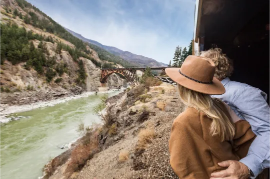 Couple enjoying panoramic mountain views from the Rocky Mountaineer observation car
