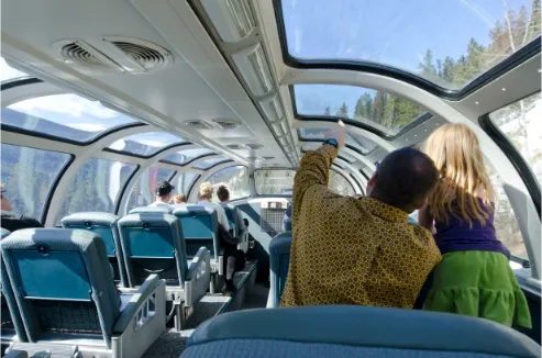 Passengers enjoying mountain views from VIA Rail's panoramic dome car
